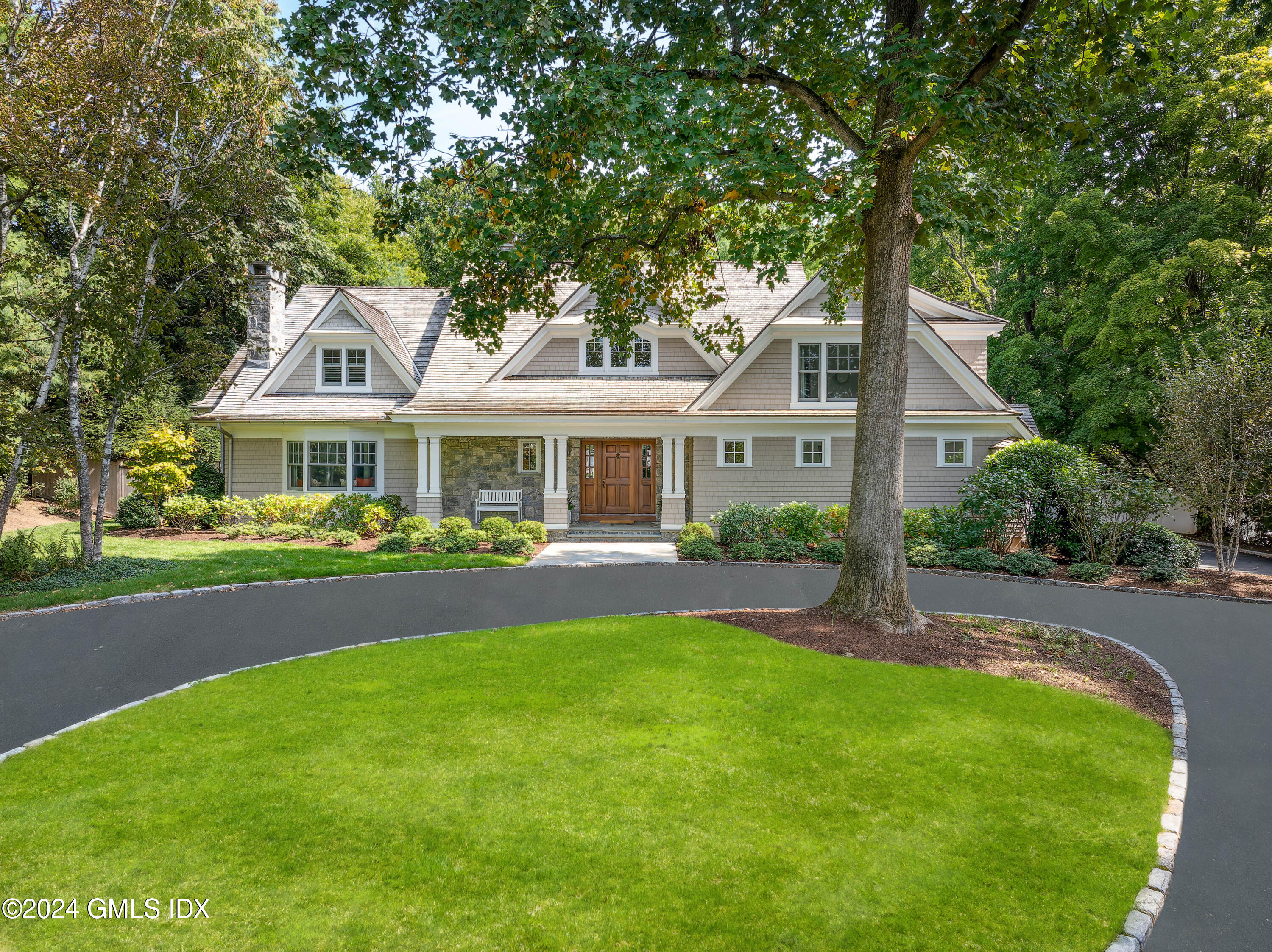 61 Indian Head Road Riverside, CT 06878 - Photo 1 of 6 a front view of a house with yard and green space