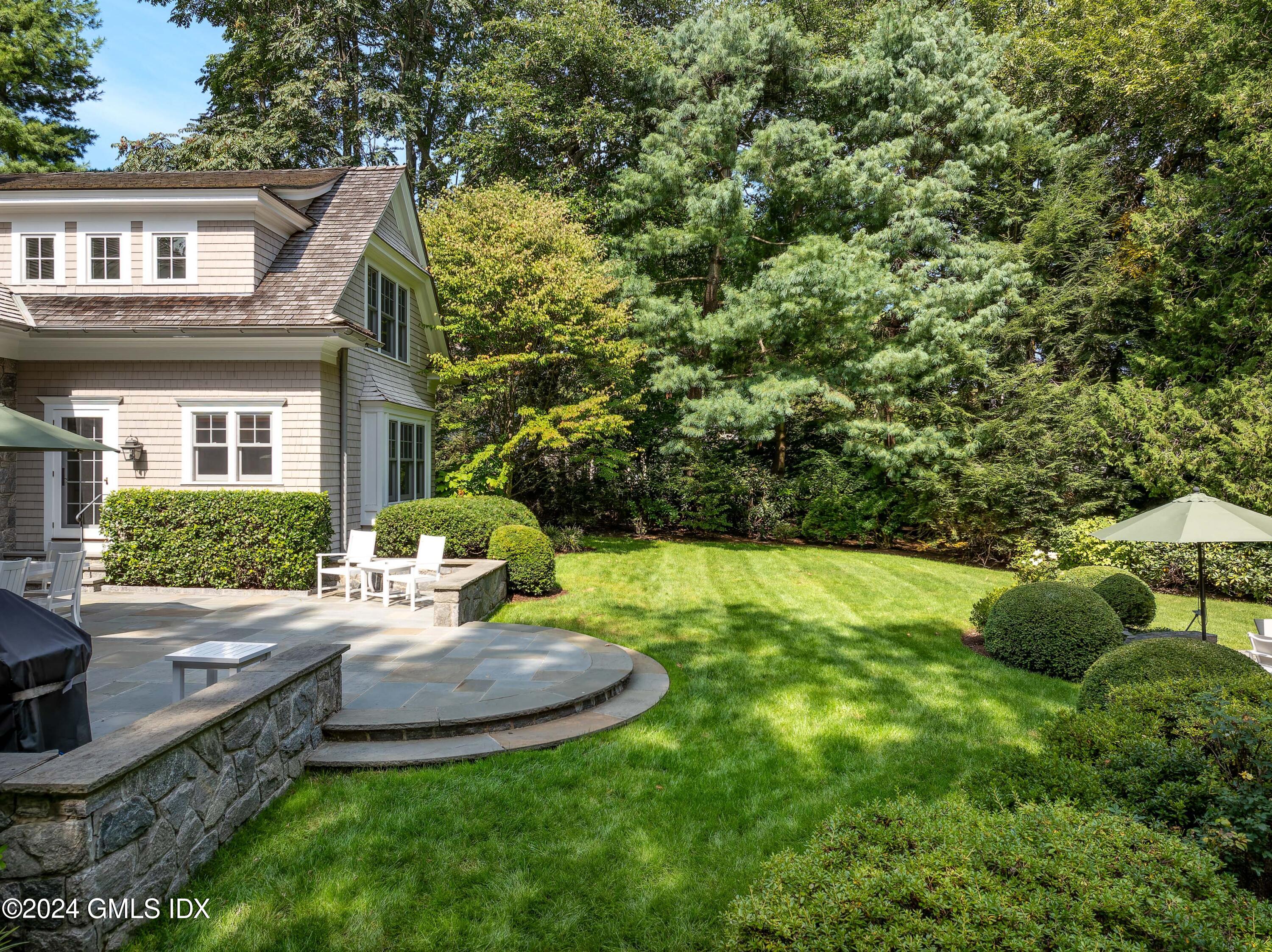 61 Indian Head Road Riverside, CT 06878 - Photo 5 of 6 a view of a house with backyard sitting area and garden