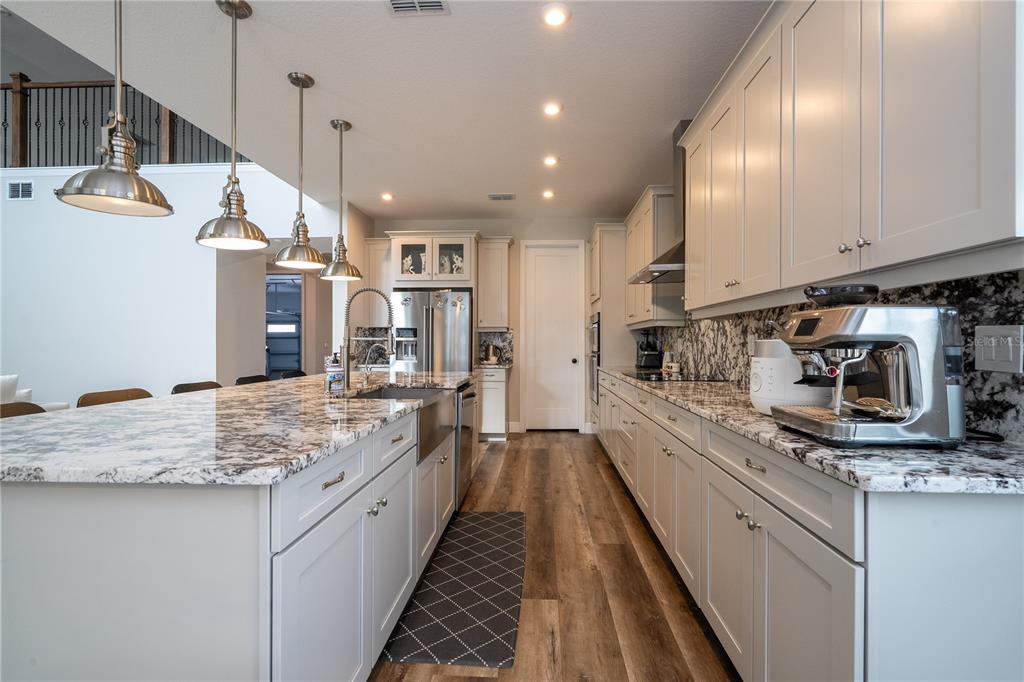 16894 Wingspread Loop Winter Garden, FL 34787 - Photo 25 of 53 a kitchen with stainless steel appliances granite countertop a sink stove and refrigerator