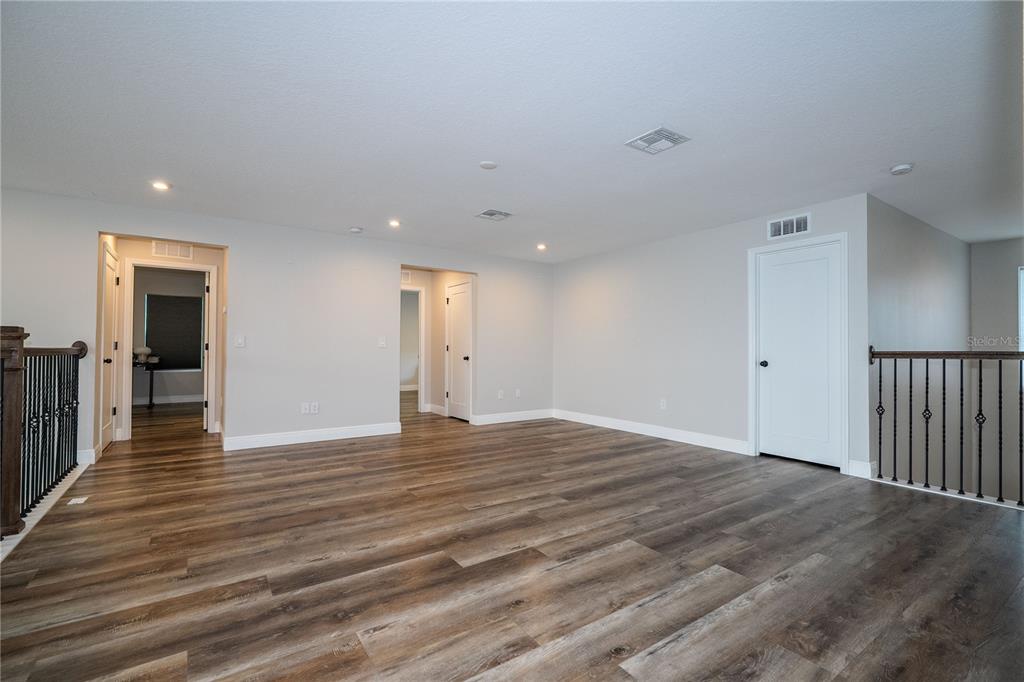 16894 Wingspread Loop Winter Garden, FL 34787 - Photo 39 of 53 a view of an empty room with wooden floor