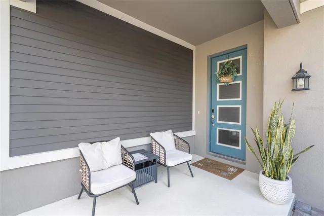 a view of a hallway to a livingroom with wooden floor and a chandelier