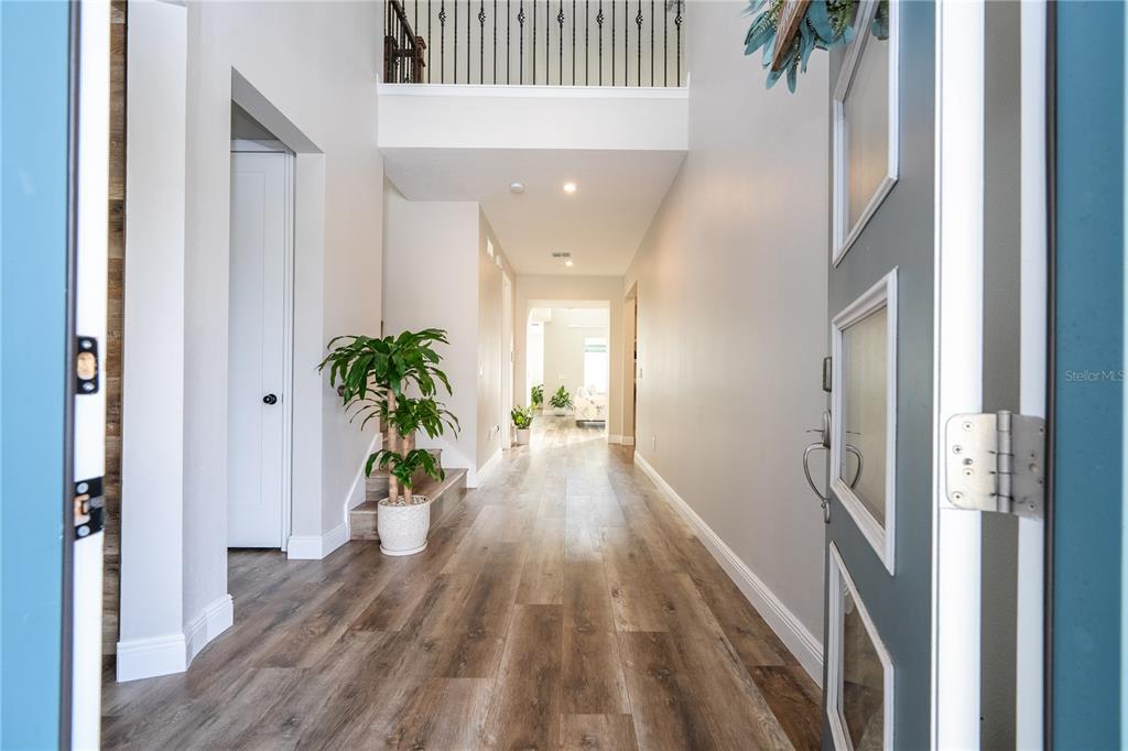16894 Wingspread Loop Winter Garden, FL 34787 - Photo 9 of 53 a view of a hallway to a livingroom with wooden floor and a chandelier