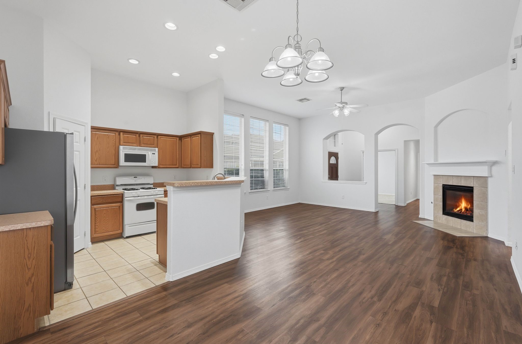18612 Syndee Loch Court Spring, TX 77379 - Photo 10 of 27 a large kitchen with stainless steel appliances granite countertop a stove oven a refrigerator and a fireplace with wooden floor