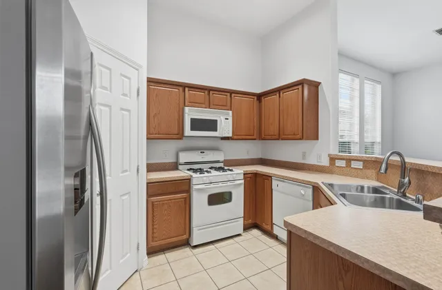 a large kitchen with stainless steel appliances granite countertop a stove oven a refrigerator and a fireplace with wooden floor