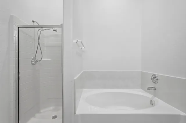 a bathroom with a tub sink and mirror