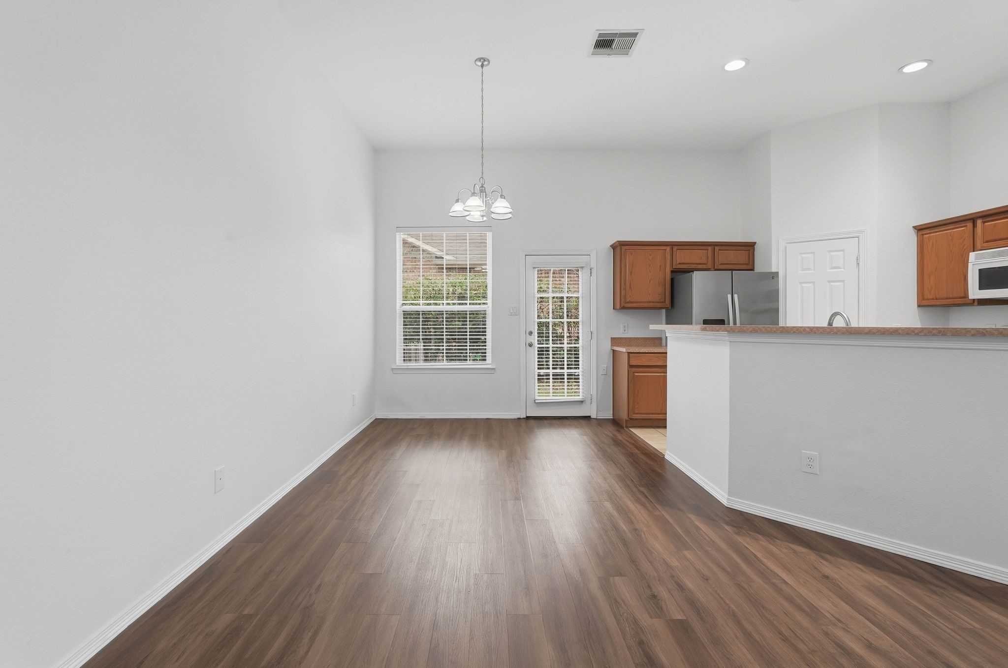 18612 Syndee Loch Court Spring, TX 77379 - Photo 9 of 27 a view of a kitchen with a sink dishwasher oven window and wooden floor