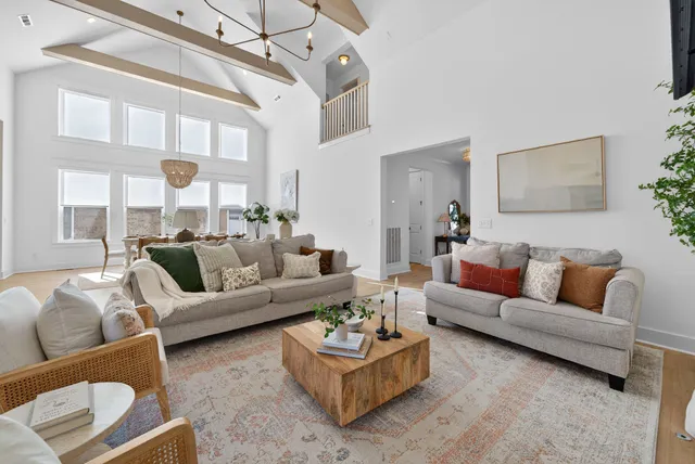 a kitchen with stainless steel appliances a dining table chairs sink and wooden floor