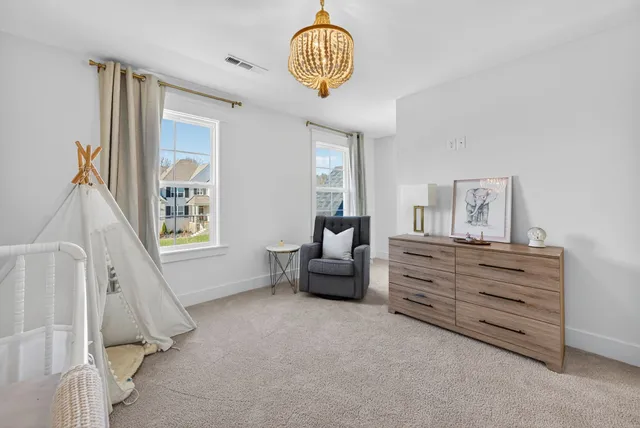 a room with lots of tables a large window and chairs