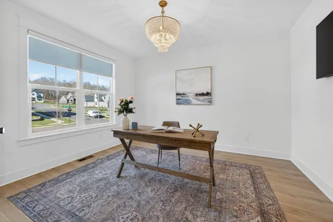 a dining room with furniture and a potted plant