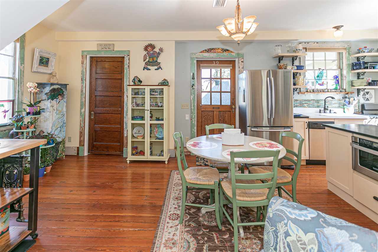 63 Marine Street St. Augustine, FL 32084 - Photo 21 of 42 a dining room with wooden floor a chandelier a wooden table and chairs