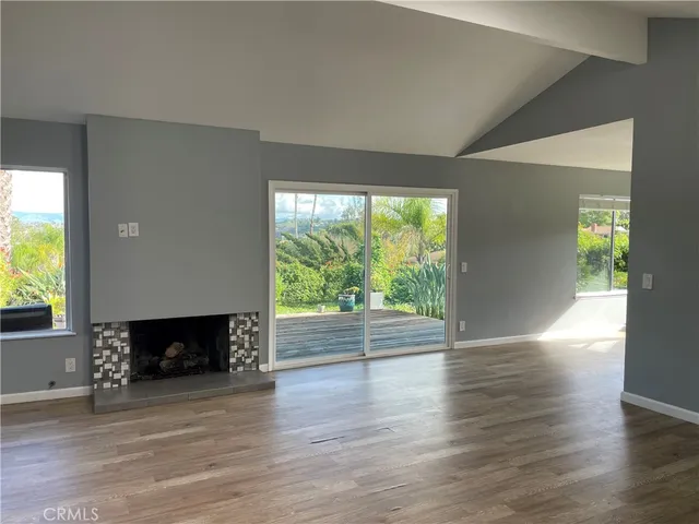 a view of empty room with wooden floor and fireplace