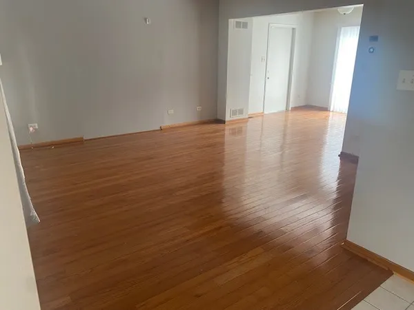 a view of an empty room with wooden floor