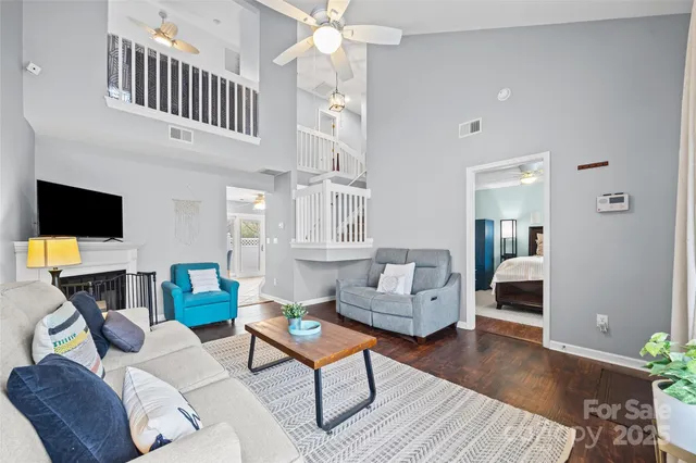 a living room with furniture a flat screen tv and kitchen view