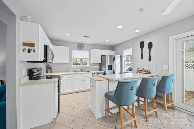 a kitchen with a dining table chairs refrigerator and cabinets