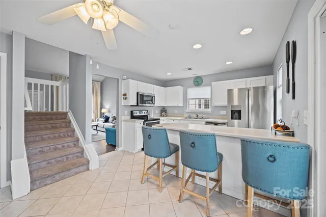 a kitchen with cabinets and chairs