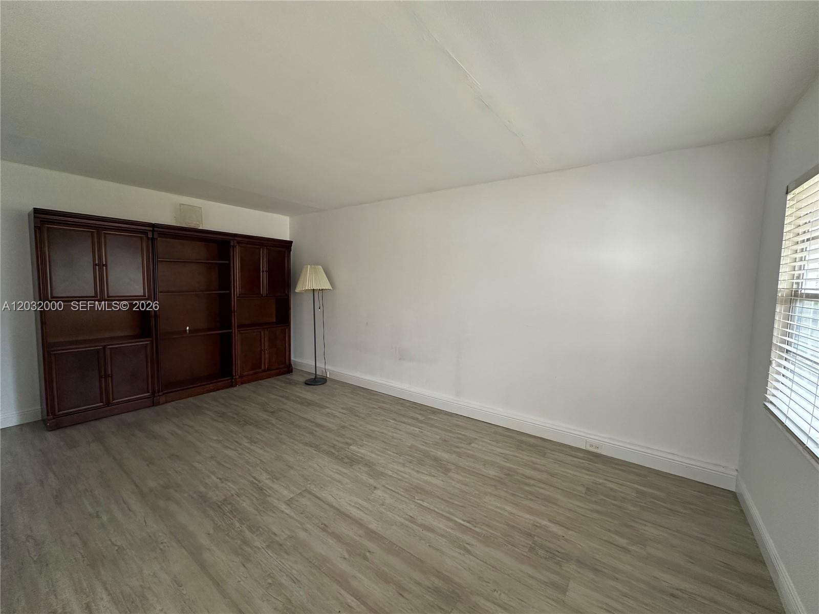 445 Mansfield K, Unit 445 Boca Raton, FL 33434 - Photo 8 of 12 a view of an empty room with a window and a kitchen
