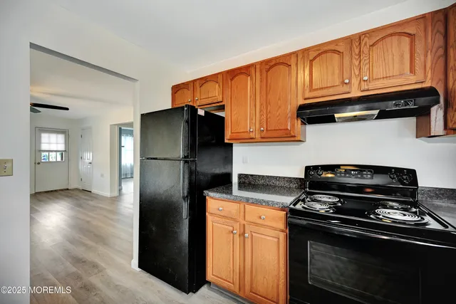 a kitchen with stainless steel appliances granite countertop a refrigerator stove and cabinets