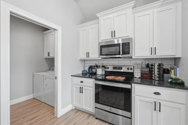 a kitchen with white cabinets and stainless steel appliances