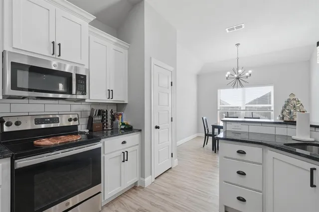 a kitchen with stainless steel appliances a stove microwave and cabinets