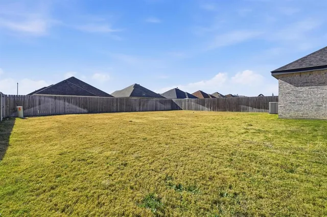 a view of a large pool with lawn chairs and large trees