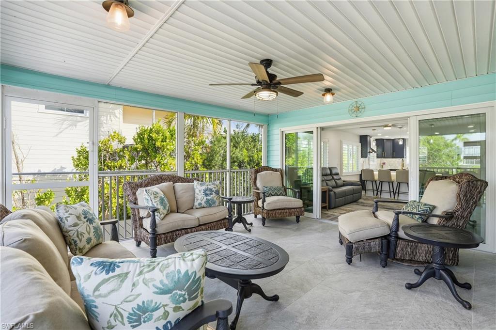 270 Dundee Road Fort Myers Beach, FL 33931 - Photo 37 of 48 Sunroom with an outdoor hangout area and ceiling fan - Virtually Edited Image