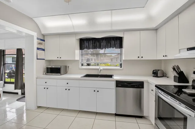 a kitchen with white cabinets and appliances