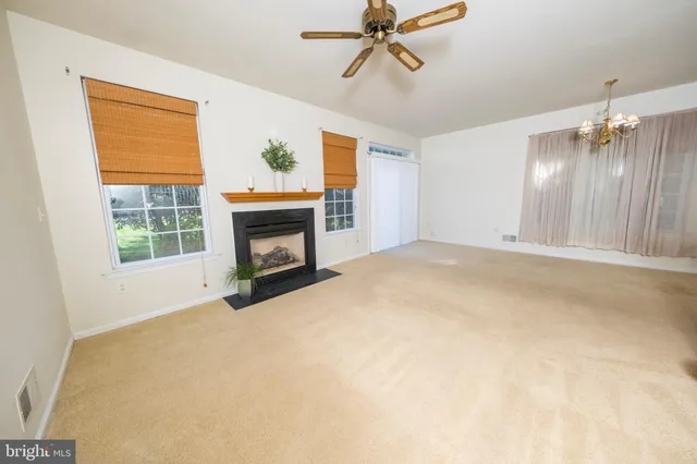 a view of an empty room with a fireplace and a window