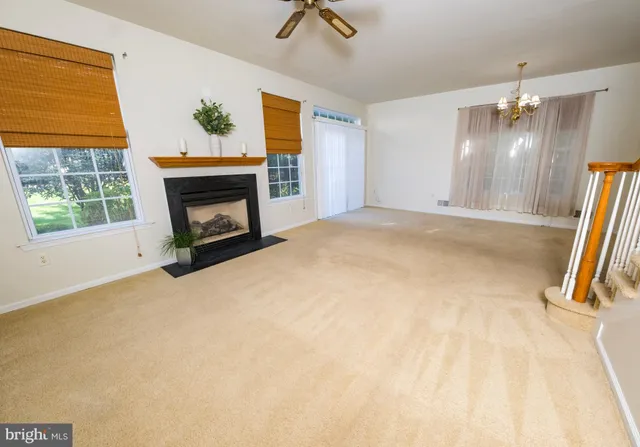 a view of empty room with fireplace and fan
