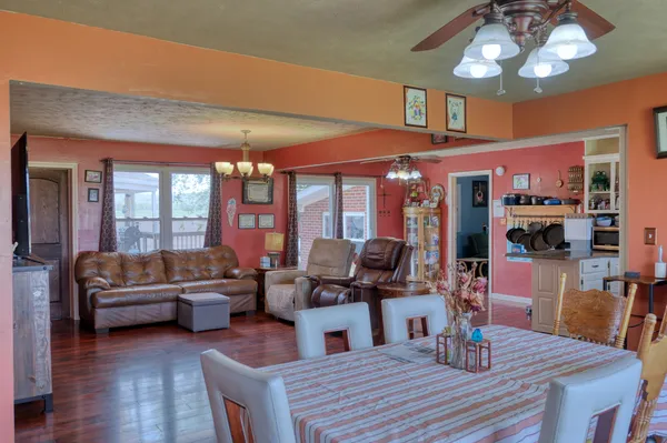 a view of a dining room with furniture a chandelier and wooden floor