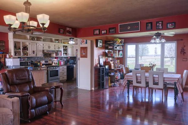 a living room with stainless steel appliances granite countertop furniture wooden floor and view kitchen