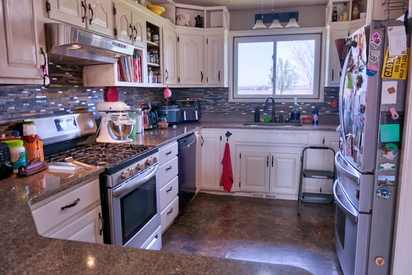 a kitchen with stainless steel appliances granite countertop a stove a sink and a microwave