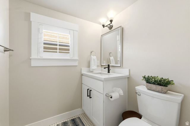 1405 Vintry Lane Murray, UT 84121 - Photo 32 of 44 Bathroom featuring a white vanity with a quartz-finish countertop, black hardware, a rectangular mirror, and a window with white trim