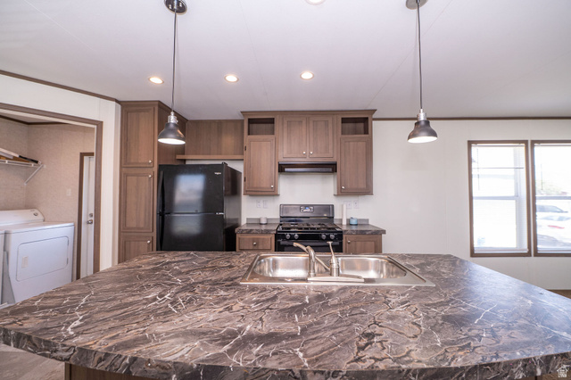 2491 Highway 89, Unit 403 Pleasant View, UT 84404 - Photo 11 of 32 Kitchen island featuring a double basin stainless steel sink with a chrome faucet, dark marbled countertop, and two pendant lights