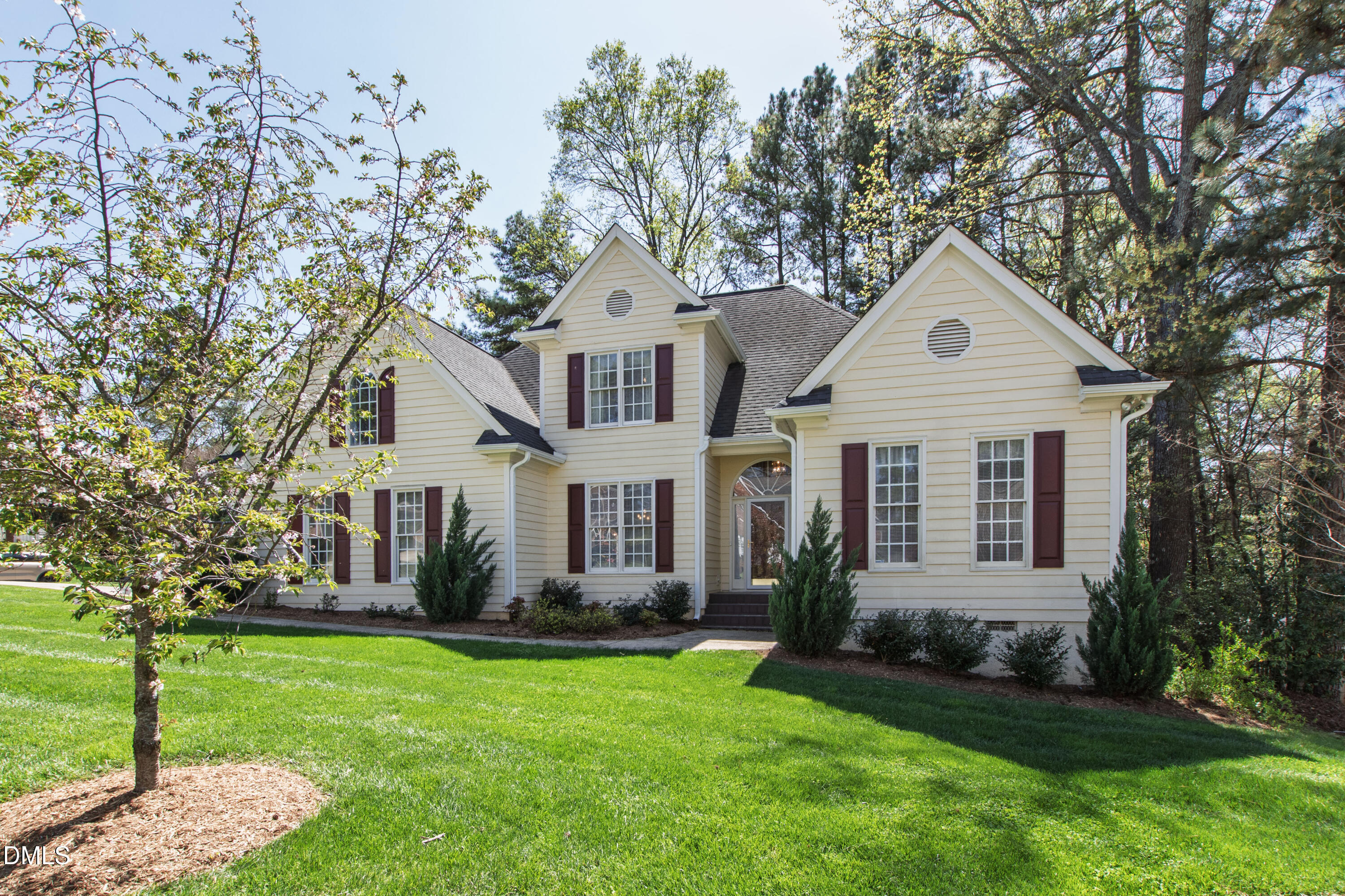 a front view of a house with a yard and trees