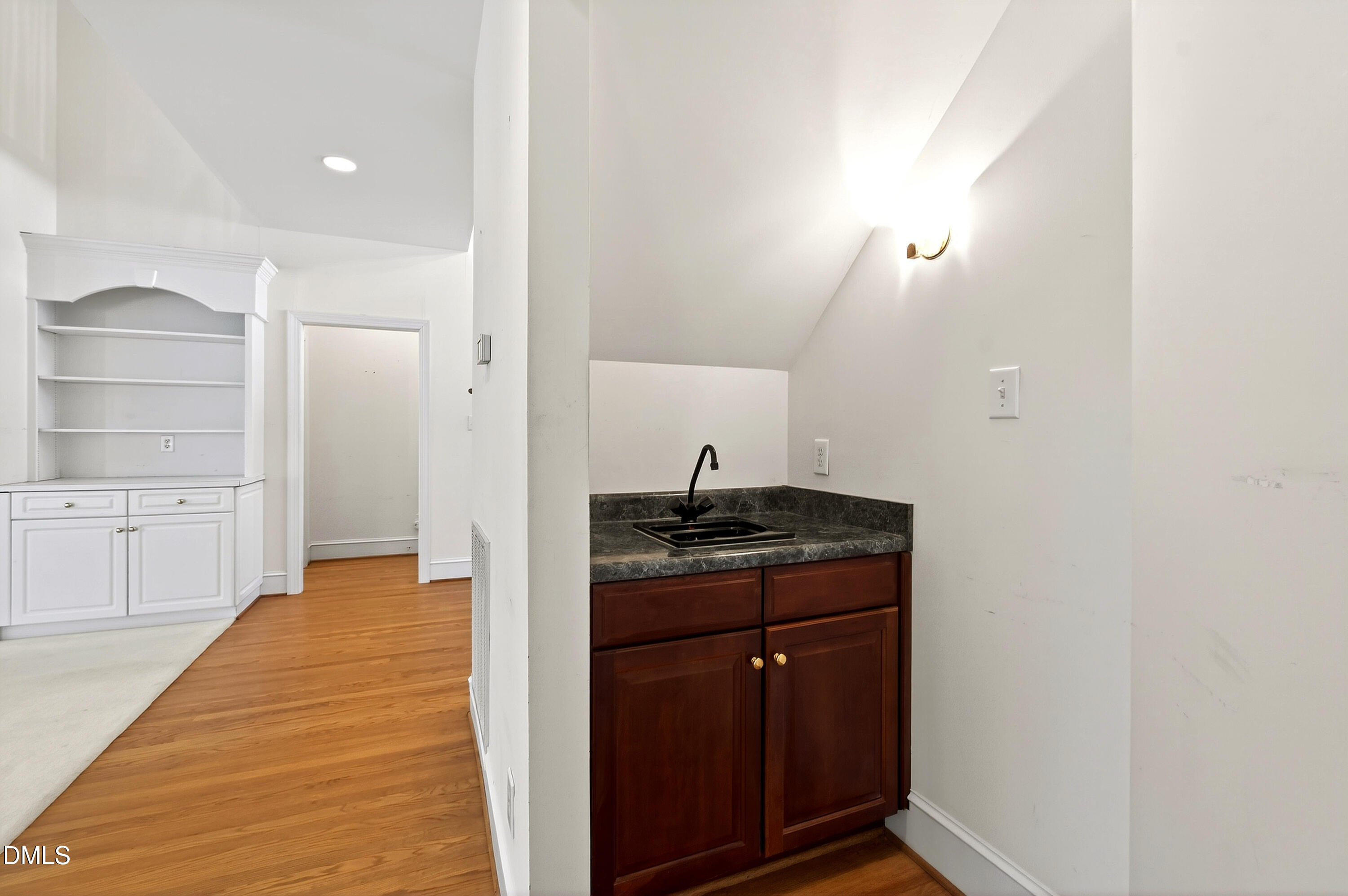 913 Tanworth Drive Raleigh, NC 27615 - Photo 13 of 48 a hallway with cabinets and wooden floor