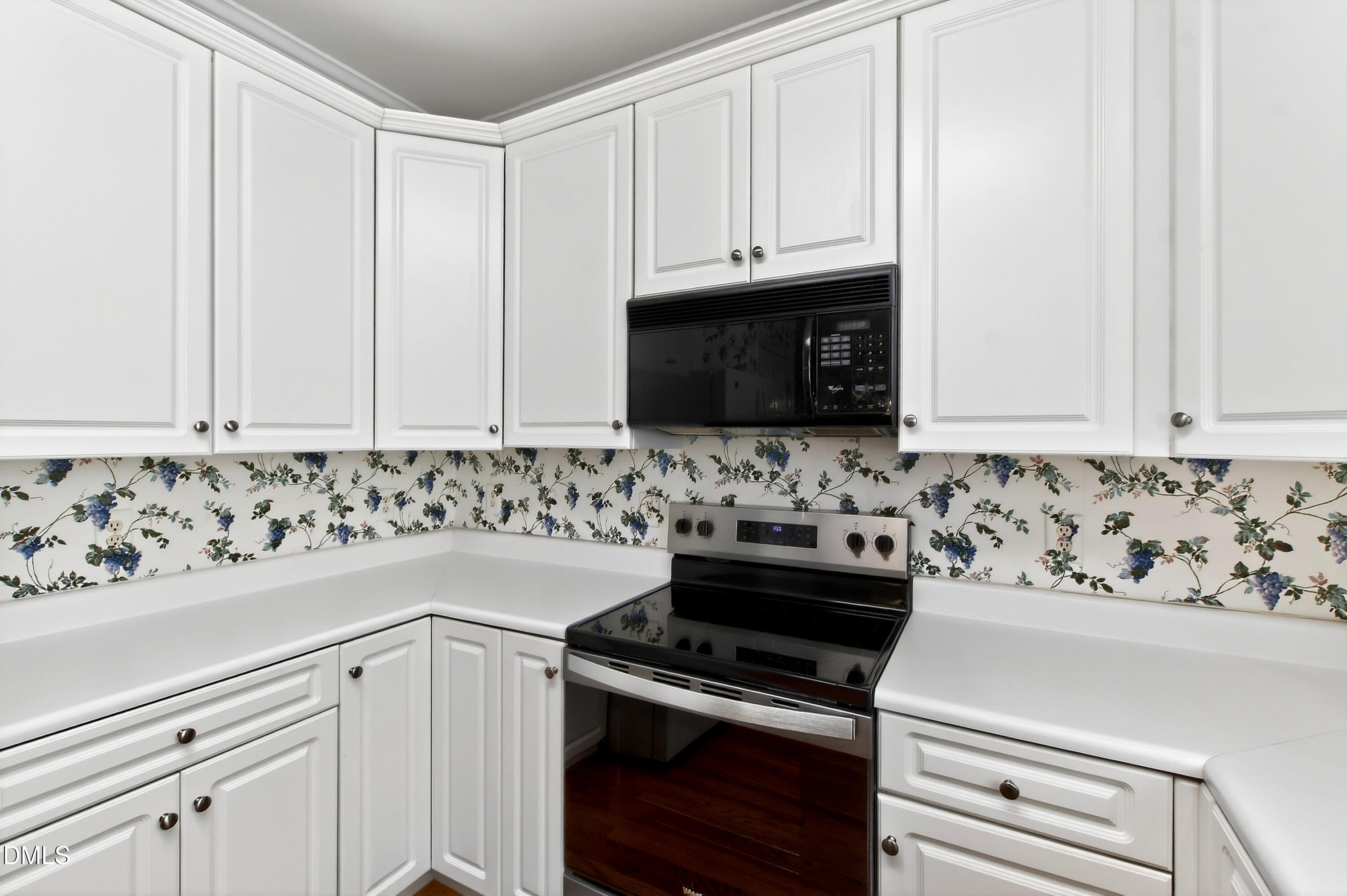 913 Tanworth Drive Raleigh, NC 27615 - Photo 18 of 48 a kitchen with white cabinets and black appliances