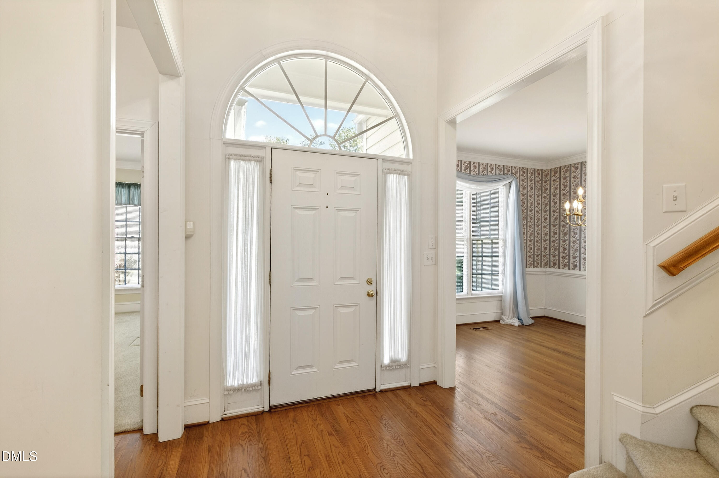 913 Tanworth Drive Raleigh, NC 27615 - Photo 3 of 48 an empty room with wooden floor mirror and windows