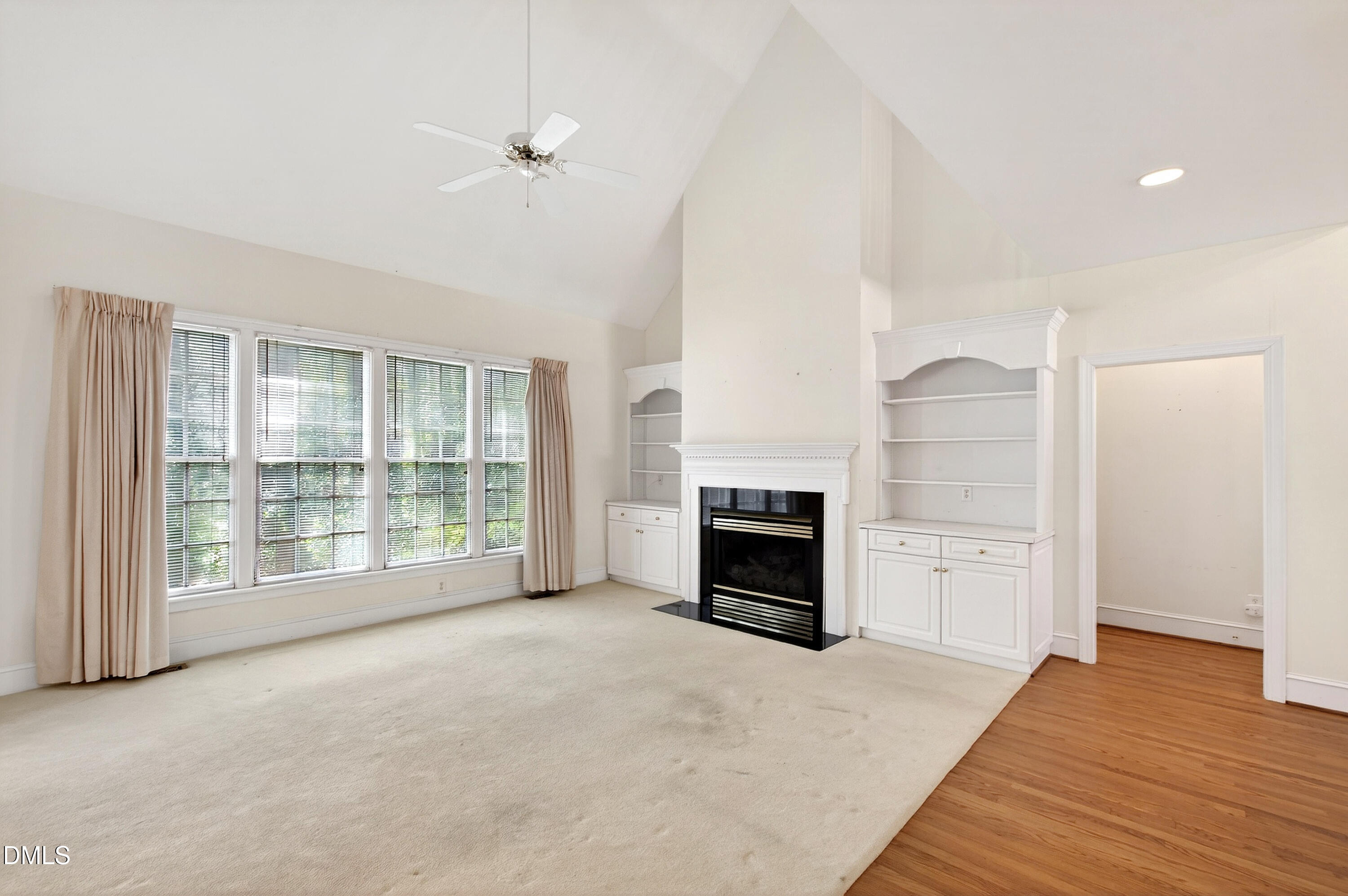 913 Tanworth Drive Raleigh, NC 27615 - Photo 9 of 48 a view of empty room with a fireplace and wooden floor