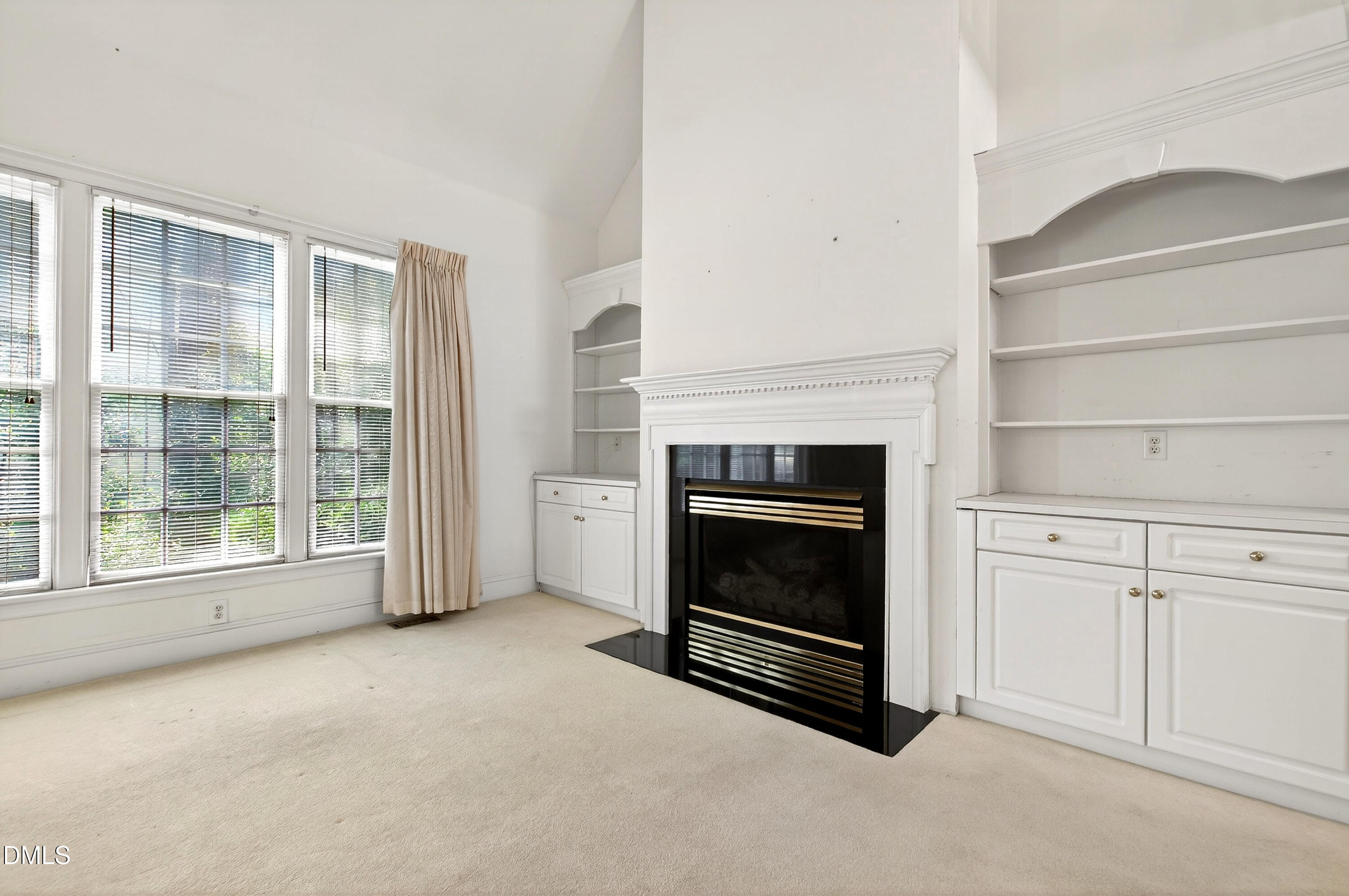 913 Tanworth Drive Raleigh, NC 27615 - Photo 10 of 48 a view of an empty room with a fireplace and a window