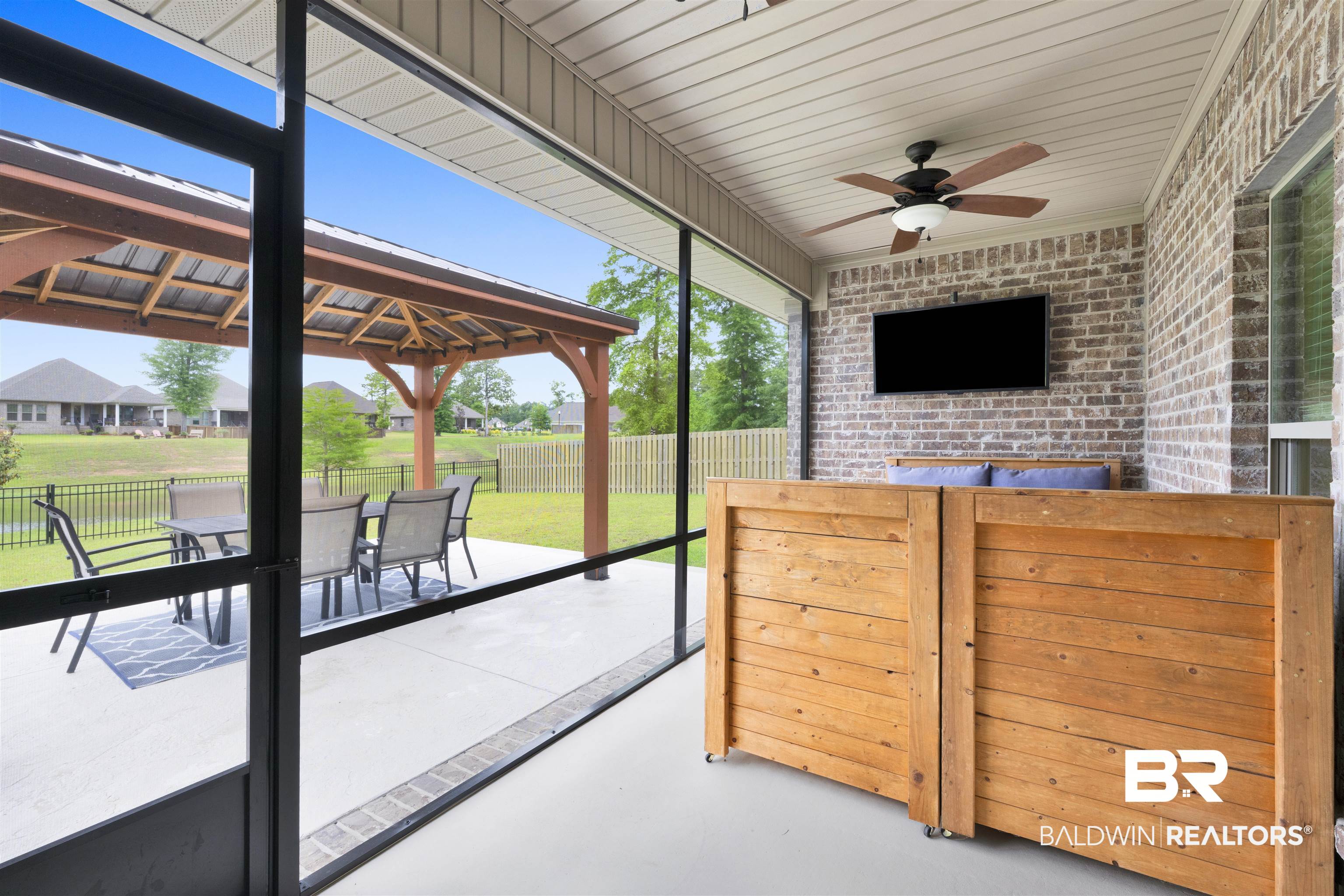 12672 Squirrel Drive Daphne, AL 36527 - Photo 34 of 49 Screened patio featuring a ceiling fan, brick wall, and wood-finish paneling