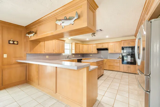 a large white kitchen with a large window and refrigerator