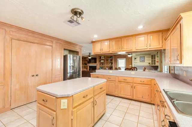 a large kitchen with kitchen island a large counter space and stainless steel appliances