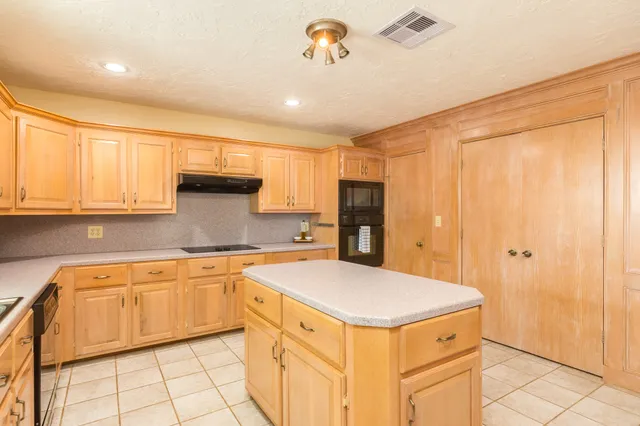 a kitchen with a sink a stove and cabinets