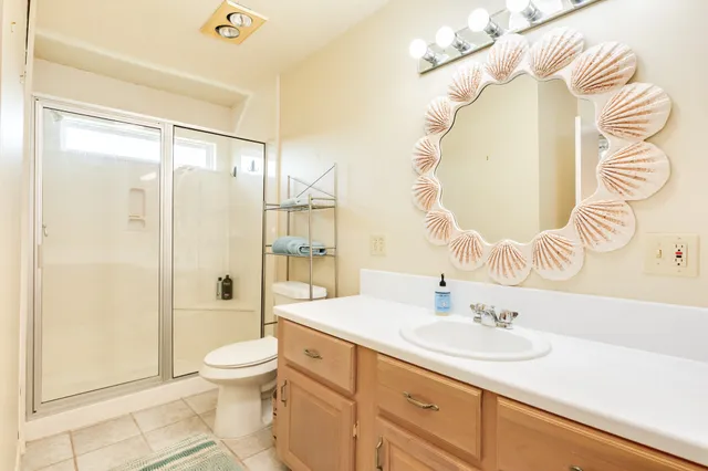 a bathroom with a sink a toilet and shower