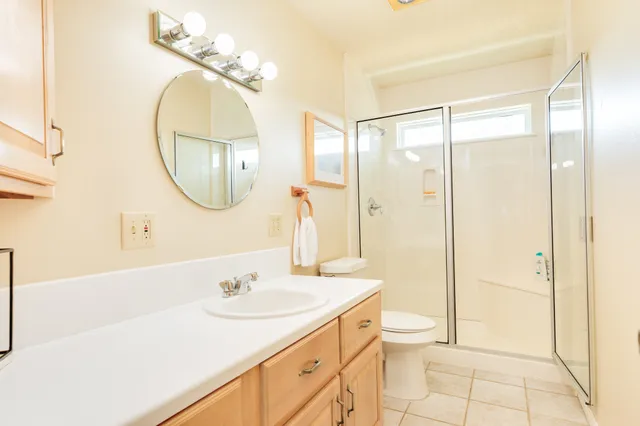 a bathroom with a sink a toilet and a mirror