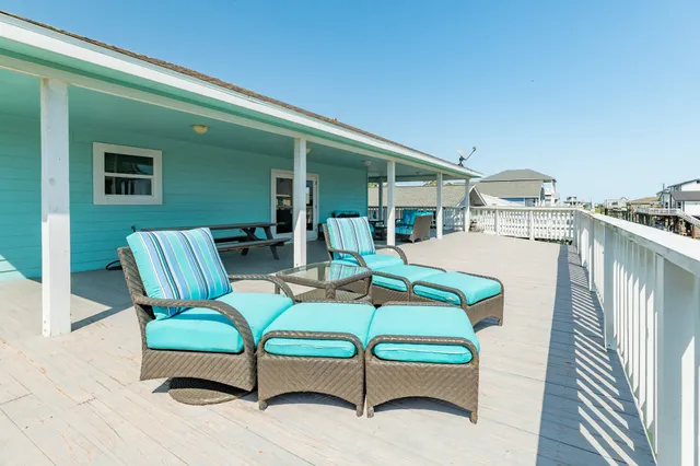 a balcony with wooden floor table and chairs