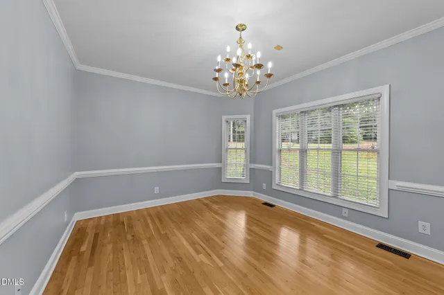 a view of an empty room with a window and a kitchen