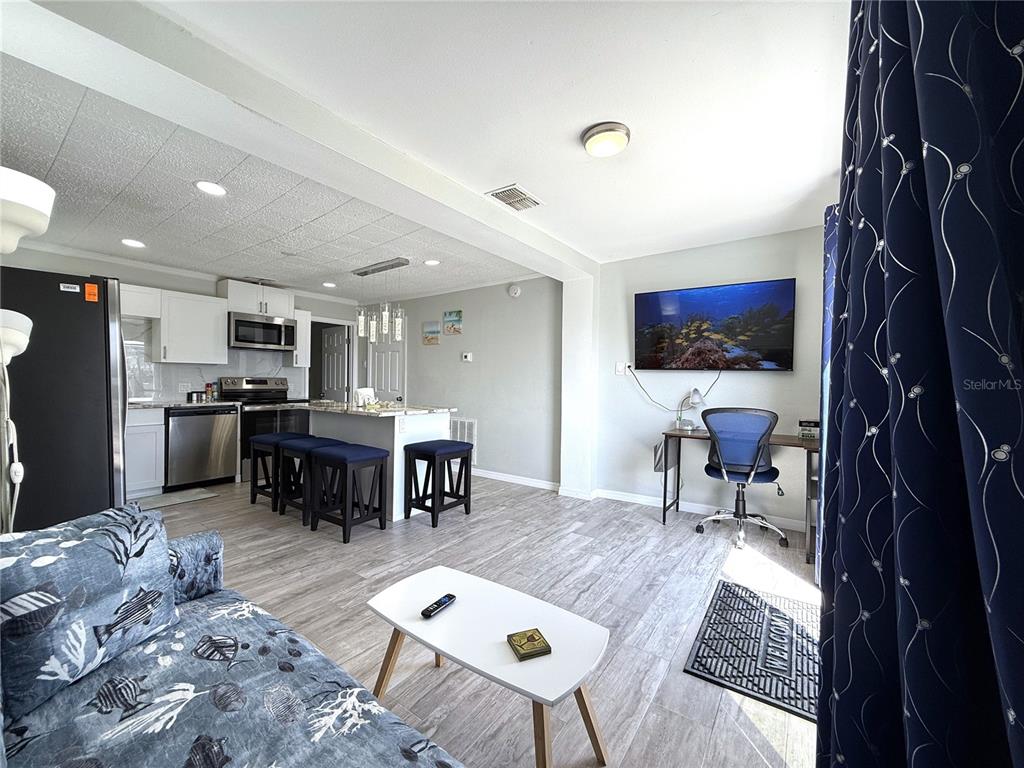 13711 Gulf Boulevard, Unit 1 Madeira Beach, FL 33708 - Photo 12 of 36 a living room with furniture and a flat screen tv