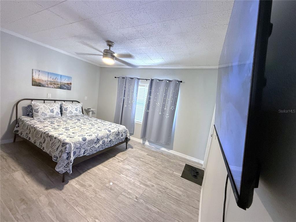 13711 Gulf Boulevard, Unit 1 Madeira Beach, FL 33708 - Photo 14 of 36 a bedroom with a bed and a large mirror