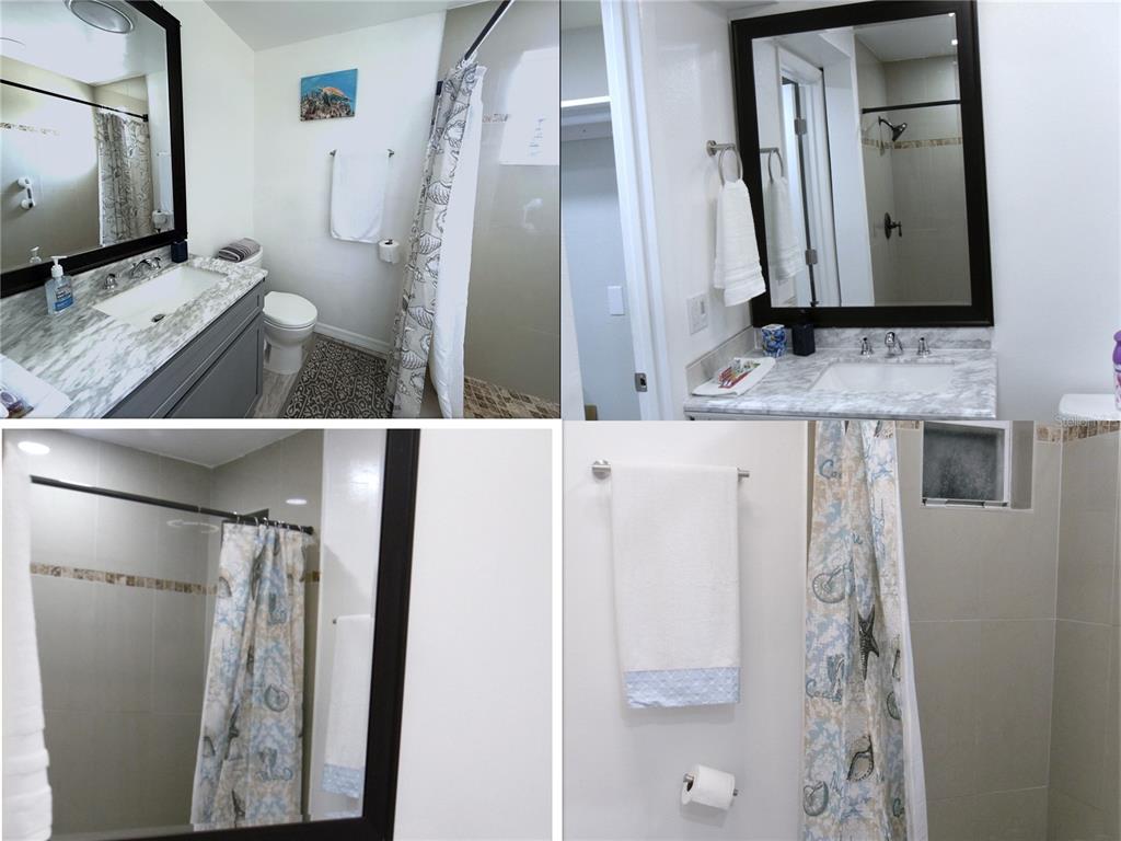 13711 Gulf Boulevard, Unit 1 Madeira Beach, FL 33708 - Photo 18 of 36 a bathroom with a sink a mirror and a shower